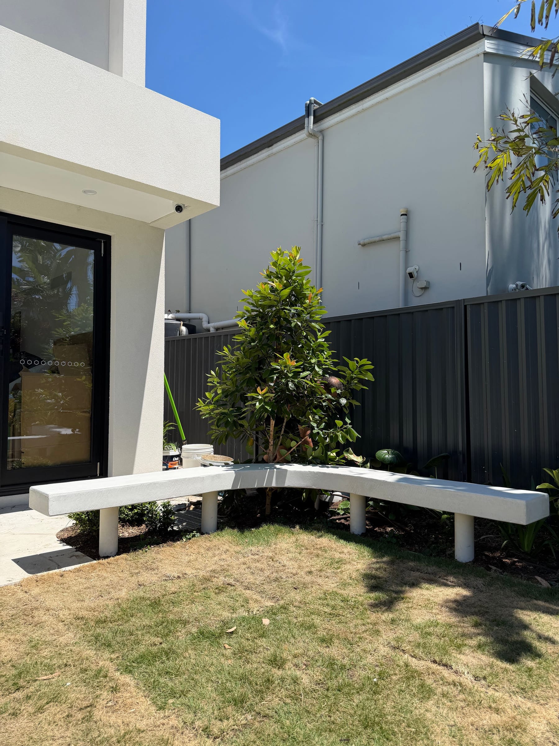 Curved floating architectural concrete bench beside pool